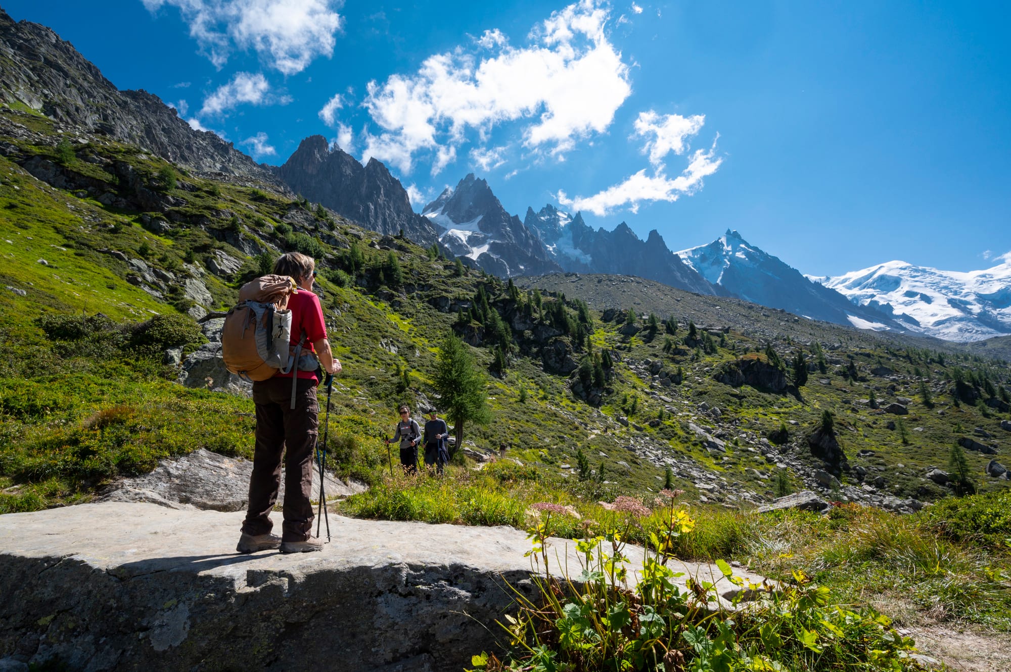 Marcheuse arrêtée face aux Aiguilles de Chamonix, sur un sentier de la vallée