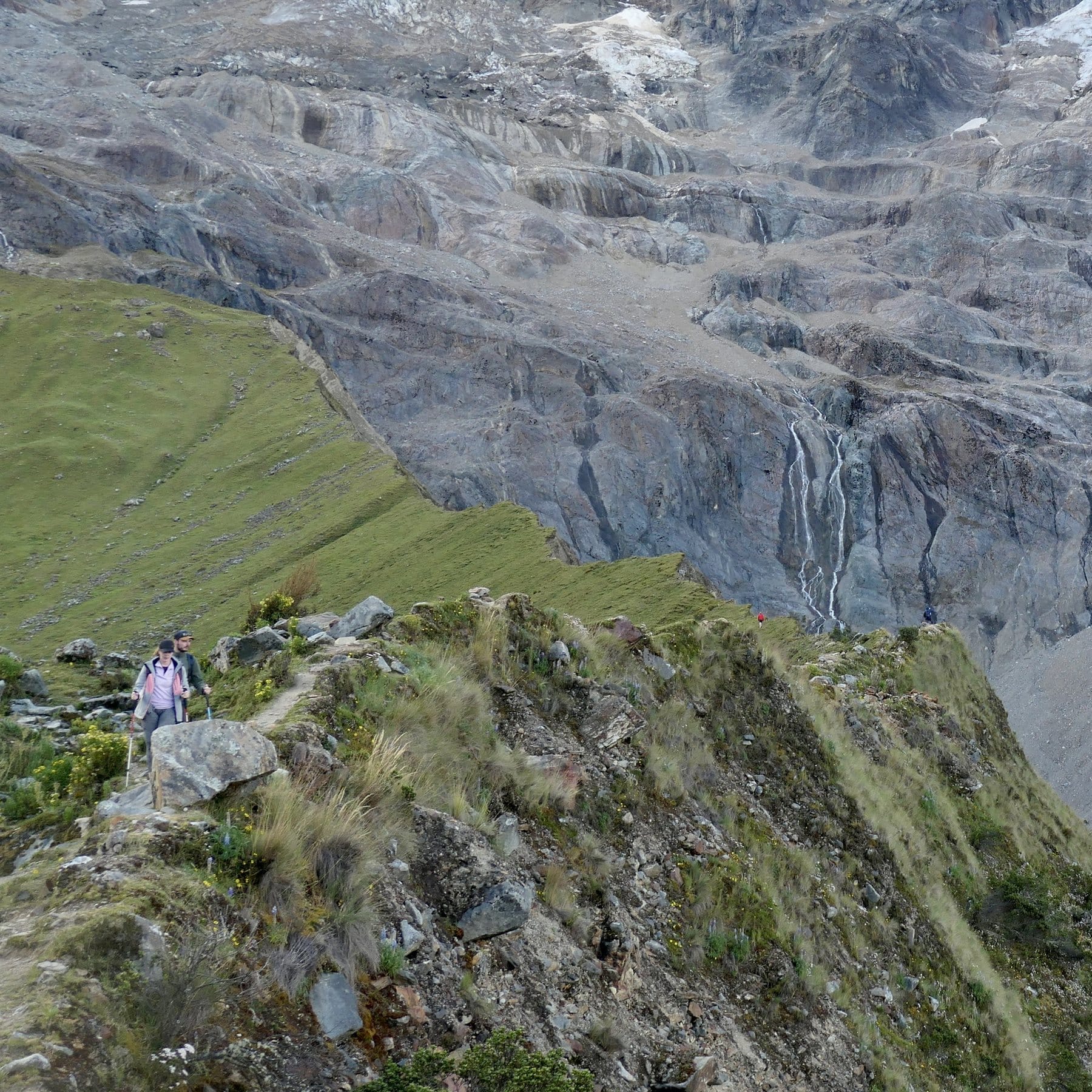 Deux marcheurs sur la crête face à la paroi et au lac, trek du Salkantay, Pérou